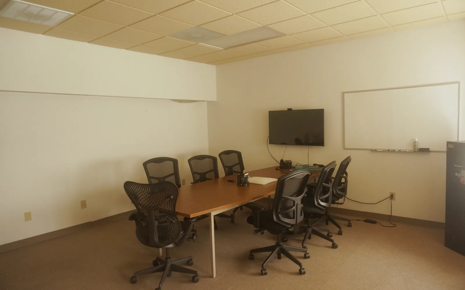 Conference room with table, display, and whiteboard